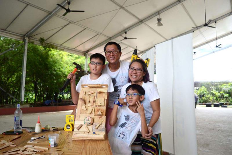 A family with their completed wooden pinball board
