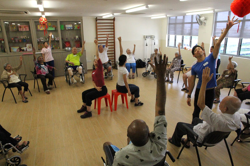 Elderly and fitness instructor going through some movement exercises