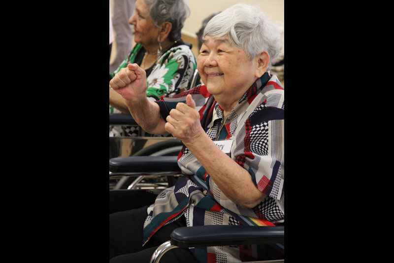 A smiling elderly women seated on a wheelchair