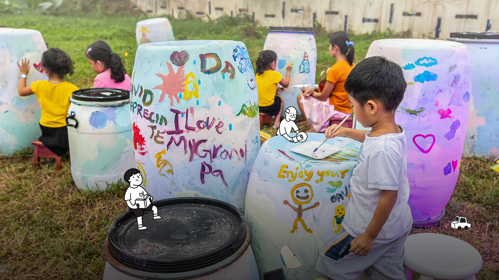 Carnival at Both Sides, Now at Telok Blangah with children using paint to decorate blue barrels in a grass patch