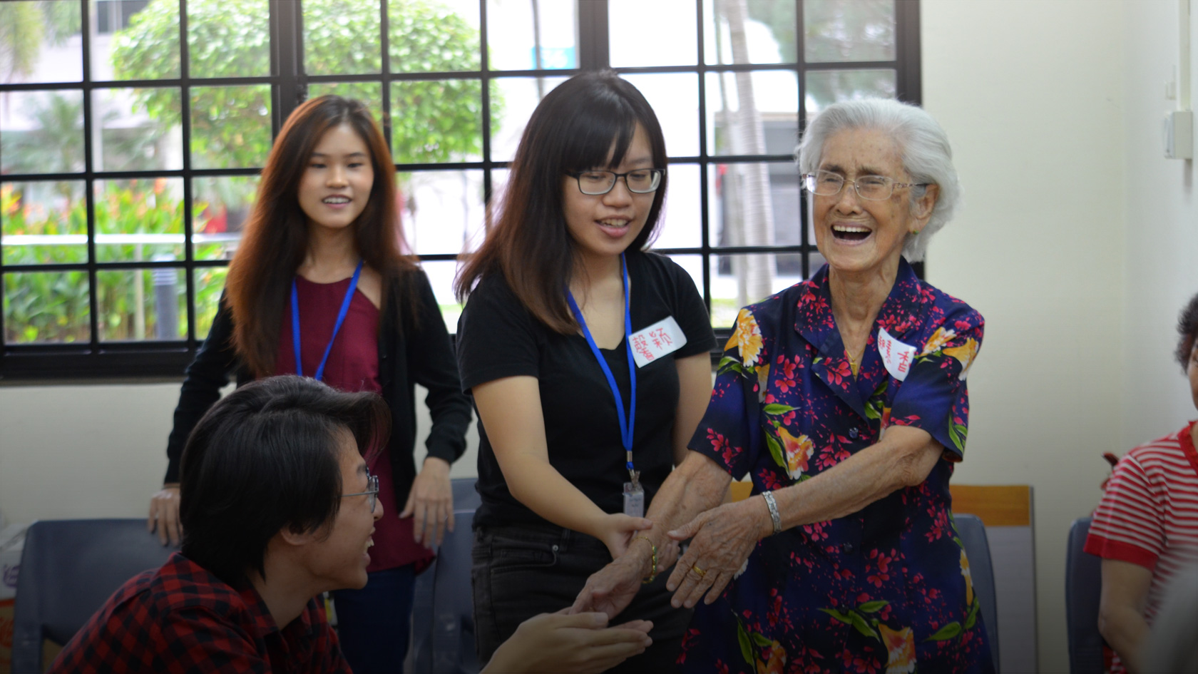 Three youth interacting with an elderly participant