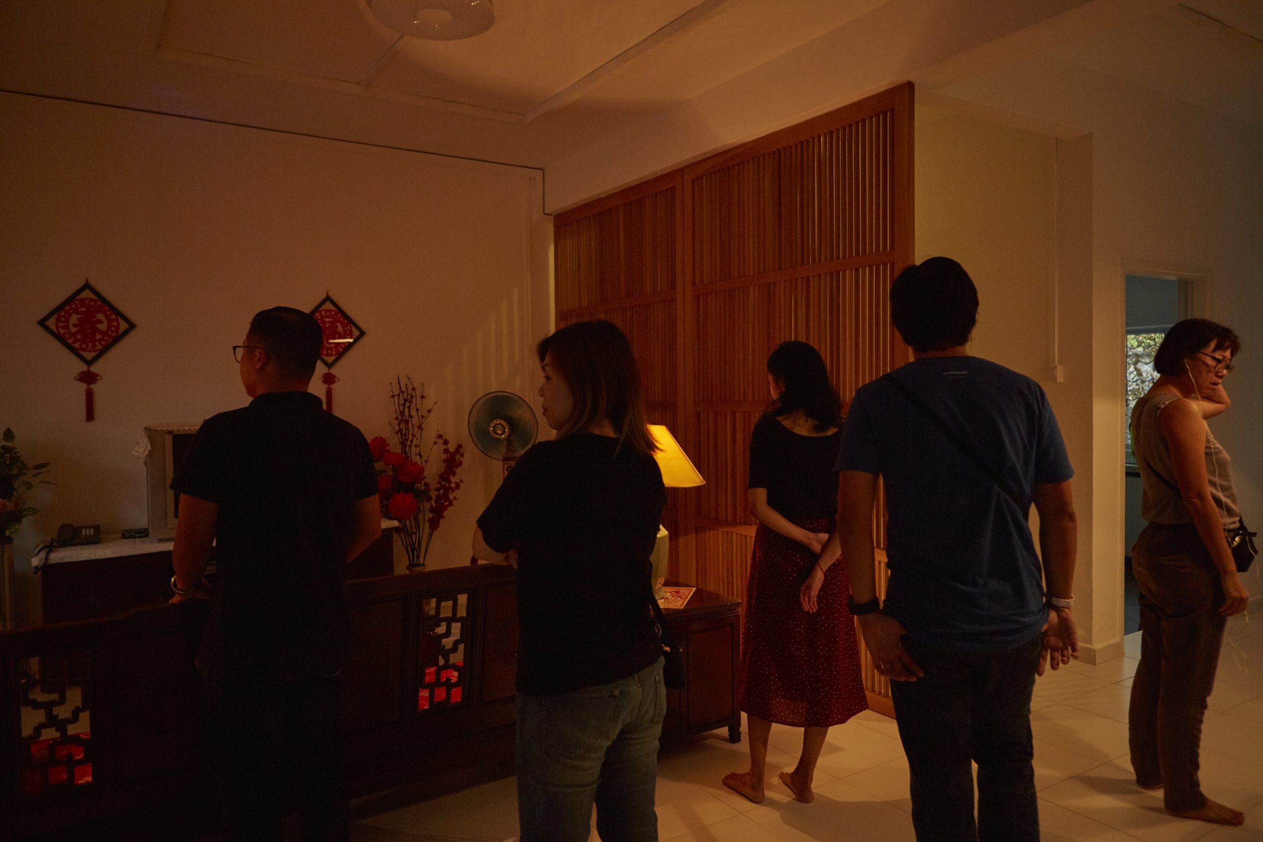 A group of five people standing in a living room used in "Flowers"