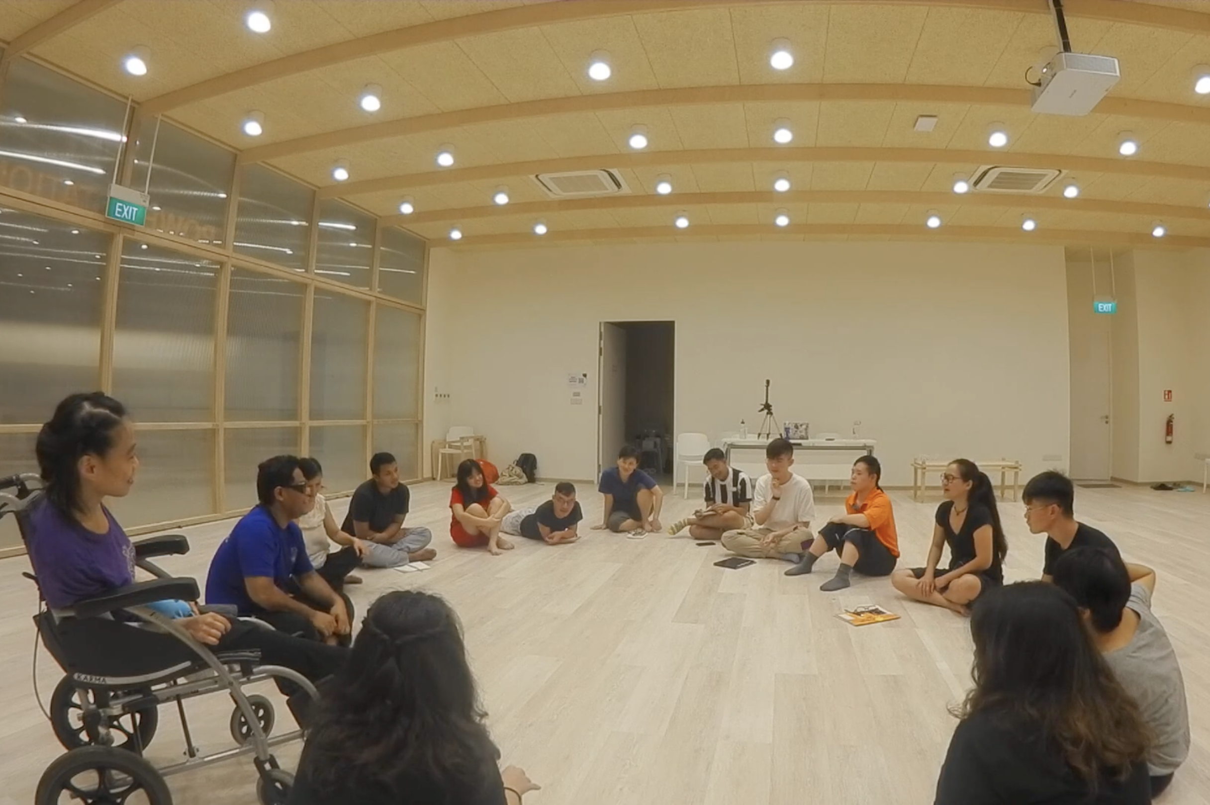 The cast and designers sitting in a circle.