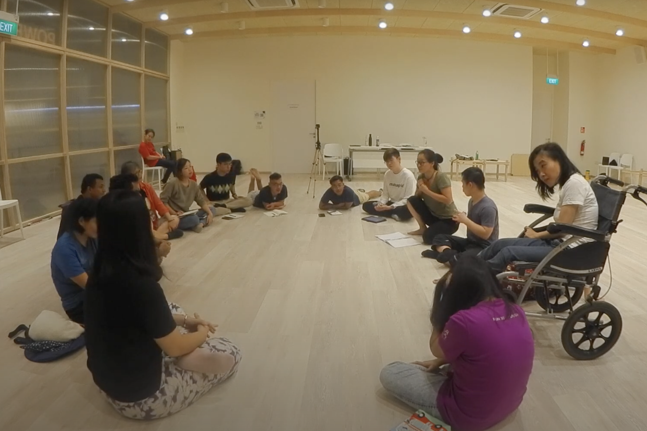 The cast and designers sitting in a circle.