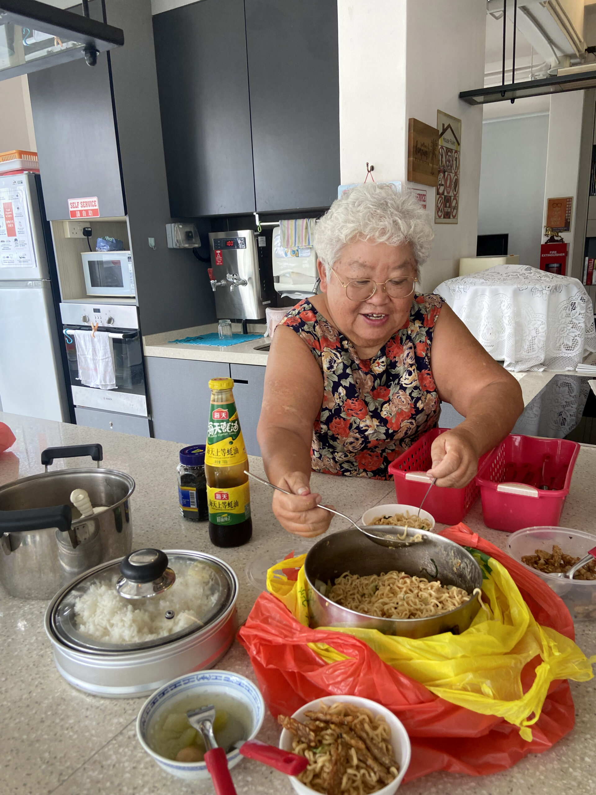 An elderly lady preparing food by the table