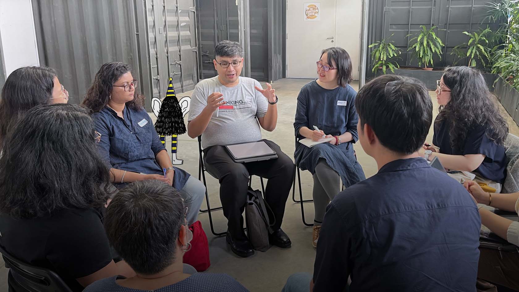 A group of practitioners seated in a circle having a discussion