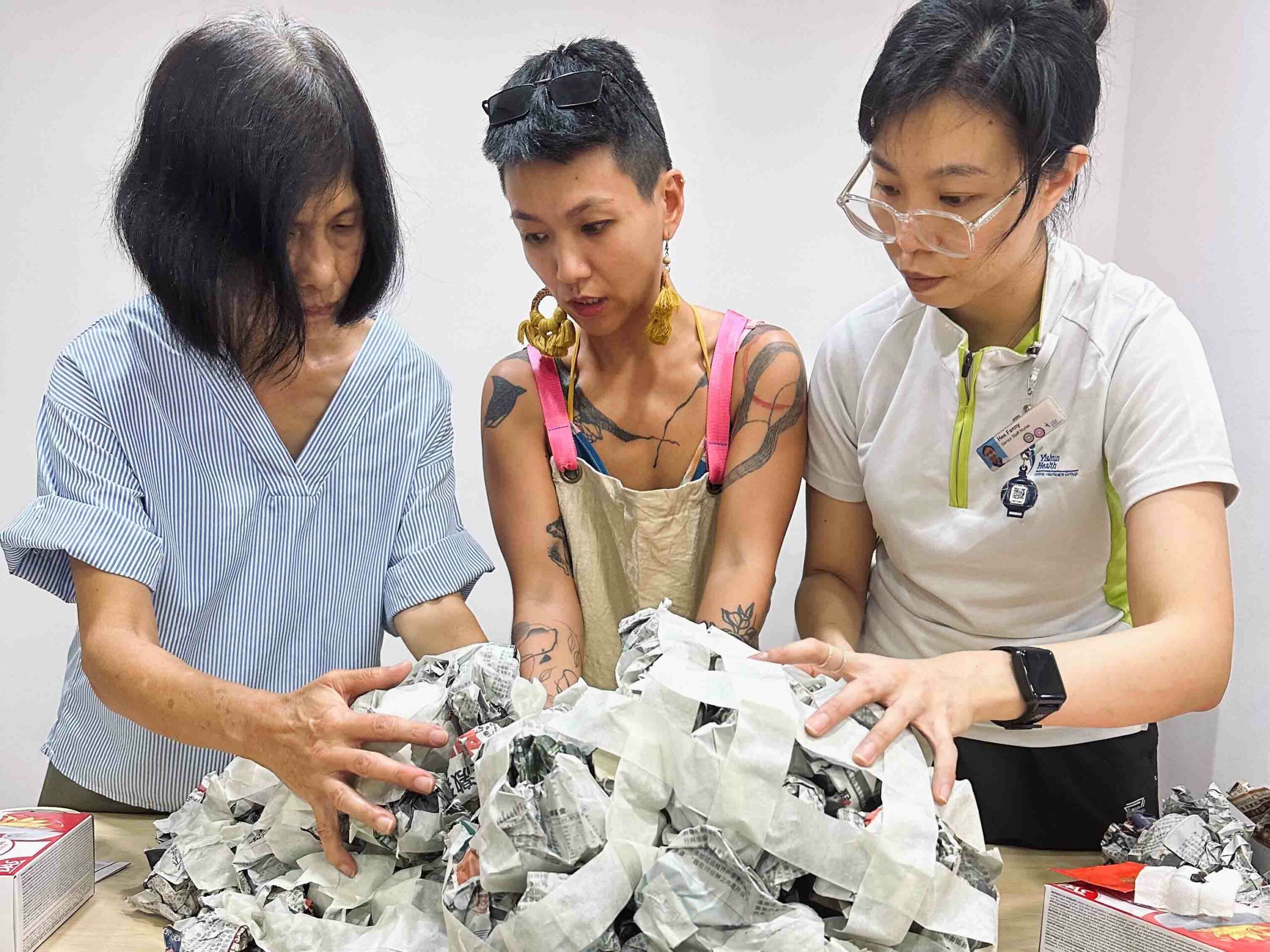 Agnes, Stacy and a Yishun Health staff member working on paper mache sculptures that make the structure of umbilical cords, where heirlooms are Agnes' focus on end-of-life matters.