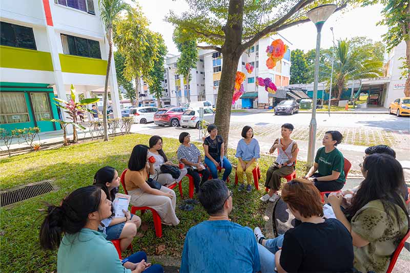 A vibrant scene of seniors, the artist, and visitors engaging with art and community during the Both Sides, Now exhibition.