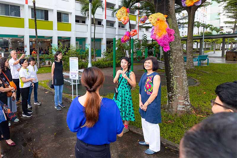 A senior and BSN volunteer looking at artwork.