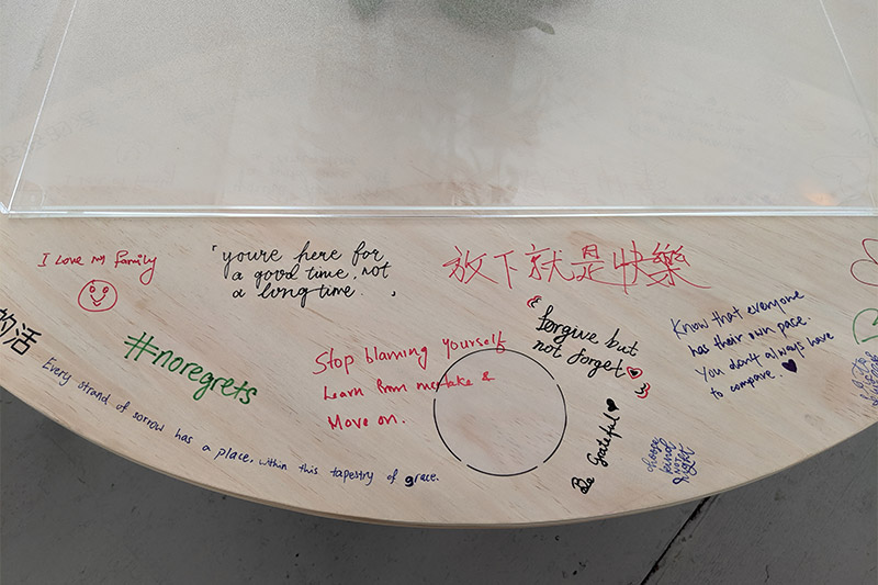 Top down view of a round table that has well wishes written in different coloured markers
