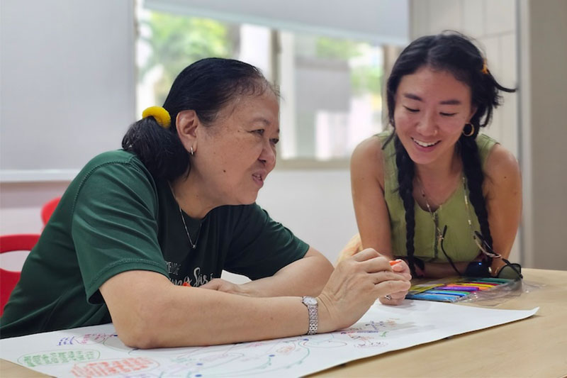 An artist facilitator and community member sitting and having a discussion.