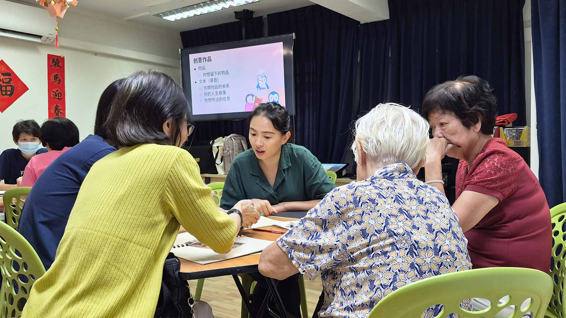 A facilitator commenting on a group of 5 workshop participants role play an end of life conversation scenario within a care setting