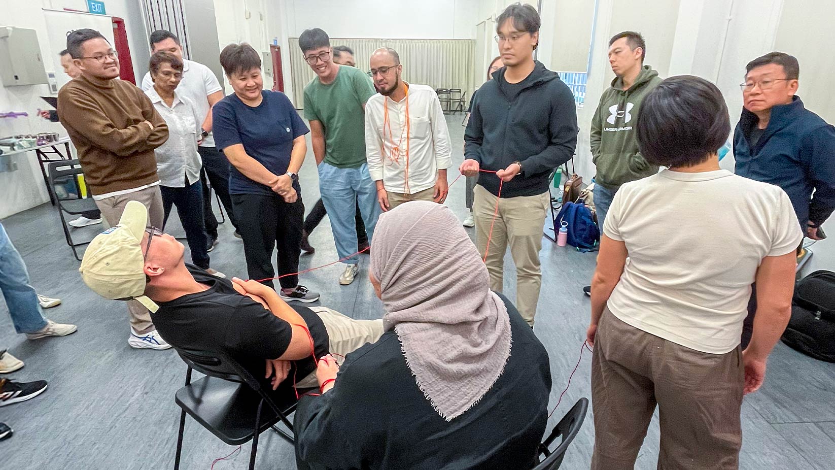 A facilitator commenting on a group of 5 workshop participants role play an end of life conversation scenario within a care setting